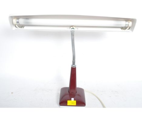 A retro vintage mid 20th century desk lamp having a wide light decorated in a burgundy red colourway with a fully adjustable 