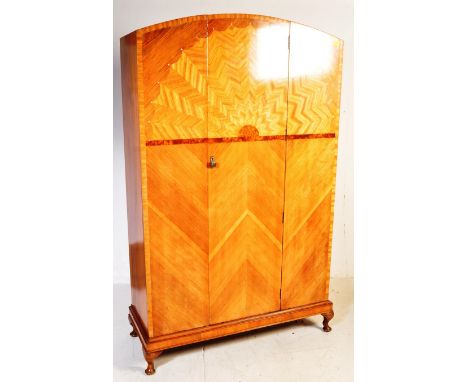 An Art Deco circa 1930s walnut sunburst domed double wardrobe having marquetry inlaid decoration to the front panel. The ward