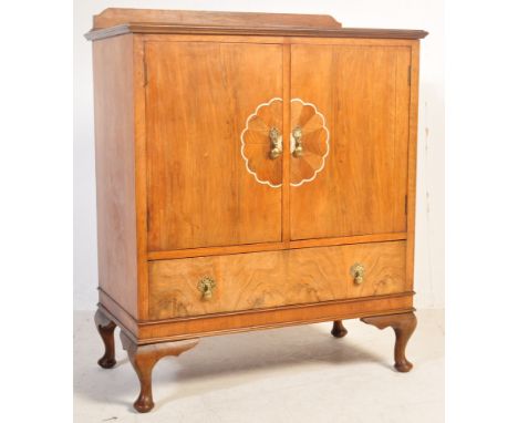 An Art Deco circa 1930s walnut tallboy having a raised gallery back, chamfered edges over a double door cabinet. The cabinet 