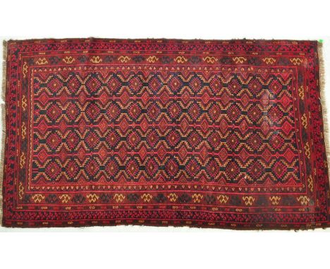 An early 20th century Islamic Turkoman Suzany rug having a central panel with a repeating geometric pattern set within outer 