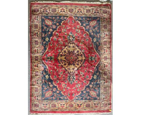 A vintage 20th century Persian Islamic rug / carpet having a central medallion surrounded by floral decoration set within a g
