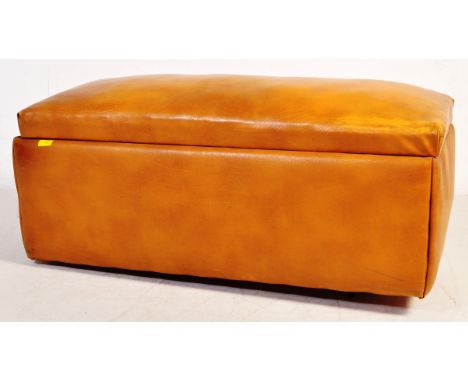 A retro vintage tan brown leather ottoman / trunk / chest. Of rectangular form with a hinged sprung covered lid opening to re