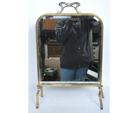A vintage Art Nouveau style 20th century standing dressing table mirror with brass frame and legs. The mirror having a stylis