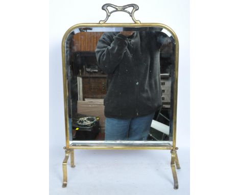 A vintage Art Nouveau style 20th century standing dressing table mirror with brass frame and legs. The mirror having a stylis