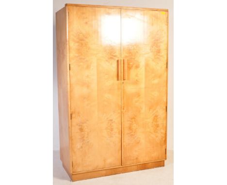 An early 20th century Art Deco figured walnut double wardrobe having quarter veneer panel doors opening to reveal a spacious 
