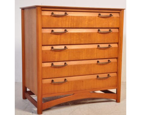 A retro vintage mid 20th century teak chest of drawers having a bank of five drawers with twin metal pulls raise on upright s