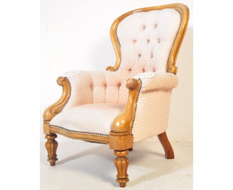 A 19th century Victorian mahogany spoon back armchair having carved scrolls to the elbow rests with serpentine base over turn