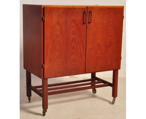 A retro vintage mid 20th century teak record cabinet having a double door cabinet opening to reveal a spacious interior raise