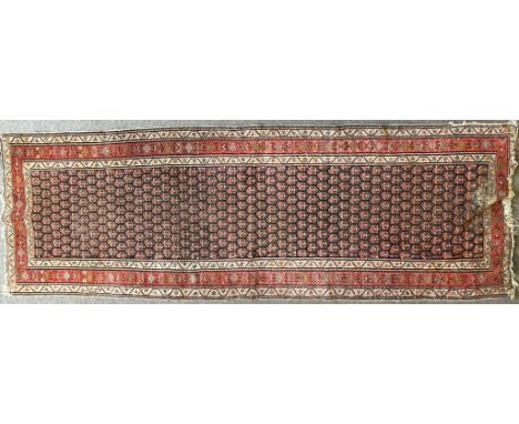 A vintage 20th century Persian Islamic floor runner rug carpet having a repeating circular motif set within a rectangular bor