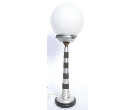 A vintage 20th century Art Deco lamp in the form of a lighthouse raised on a circular base. The lamp has a globular shade. Me