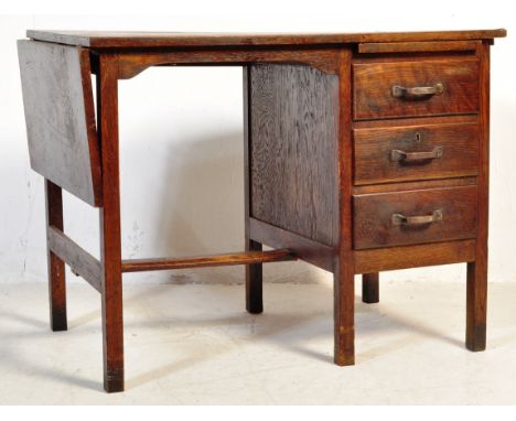 A vintage mid 20th century circa 1920s oak desk having a kneehole to the left and bank of drawers to the right raised on upri