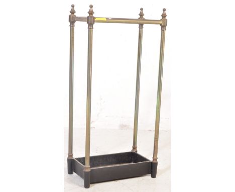 A vintage 20th century brass and cast iron stick / umbrella stand having finials to each corner raised on upright tubular sup