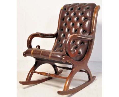 A 20th century upholstered mahogany and leather slipper rocking chair. The armchair being upholstered in brown leather with b