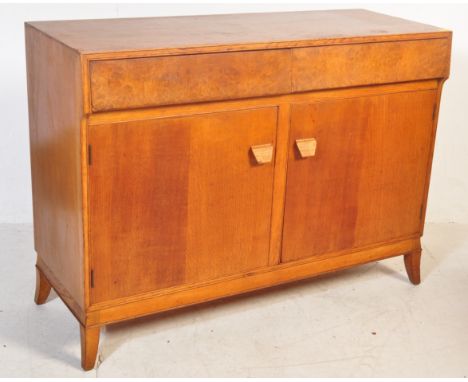 A 1930's oak Cotswold School sideboard credenza in the manner of Edward Barnsley. The sideboard being raised on angled taperi