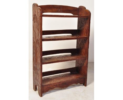 A vintage 20th century Art Nouveau style carved hardwood open faced bookcase having fine detailing throughout raised on uprig