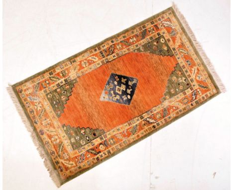 A vintage 20th century Persian / Islamic rug carpet having a central blue medallion within a larger orange medallion with spa
