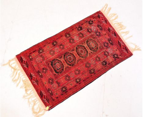 A vintage 20th century Persian Islamic carpet / rug having a red background with four central medallions with geometric patte