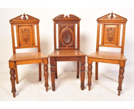 A pair of Victorian 19th century hall chairs, each having a pediment top, panel seat raised on turned legs. Together with ano