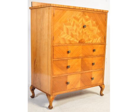 An Art Deco circa 1930s walnut sunburst tallboy having a stub gallery back with marquetry inlaid decoration to a fall front a