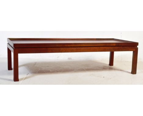 A retro vintage mid 20th century teak coffee table of rectangular form having a raised edge and square upright supports. Meas