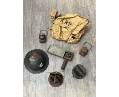 A British ARP warden's helmet with ARP satchel, gas rattle, lanterns, car head lamp covers etc 