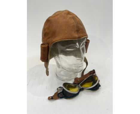 A mid 20th Century tan leather flying helmet together with a pair of pre-war flying goggles a/f (2) 