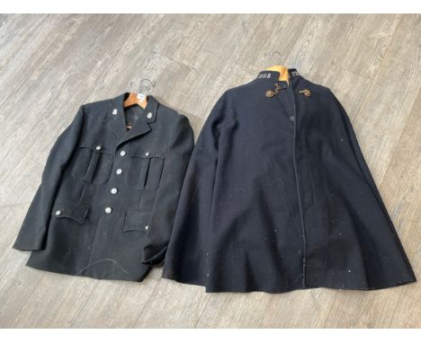 A 1940’s/50’s police cloak with lion’s head brass fastenings and collars numbered 1255, together with a North Wales police ja