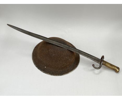A 19th Century French Chassepot bayonet, no scabbard, together with a British WWII helmet shell, corroded (2) 