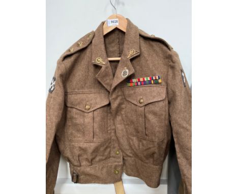 A 1949 pattern battledress blouse, size 11, dated 1954, Royal Artillery insignia and WWII medal bars, some moth holes 