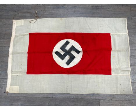 A Third Reich era German flag, the black swastika within a white roundel, upon a red rectangle, deep white border. Provenance