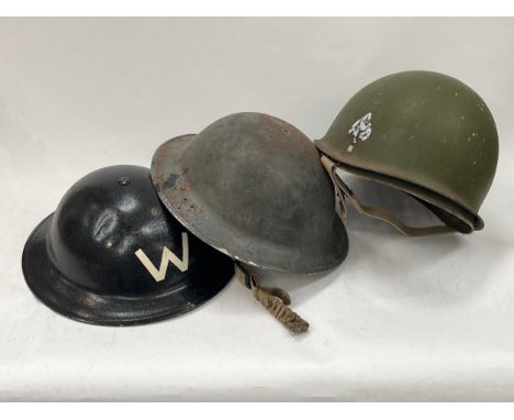A British Army helmet repainted in black with W for Warden, a helmet shell and a post-war US helmet (3) 