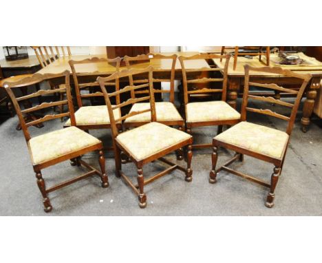 A set of six oak ladder back chairs shaped top rail and splats drop in seat turned forelegs H - stretcher.