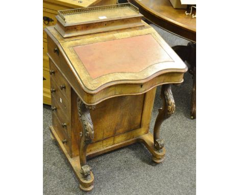 A walnut veneered davenport, brass spindled three quarter galleried cover to pen tray, serpentine front to leather inlaid slo