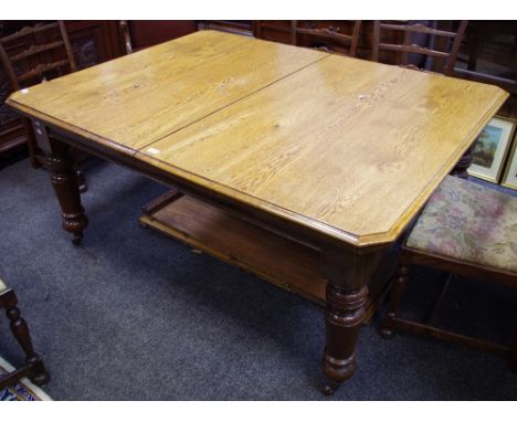 A Victorian oak and mahogany wind out dining table. canted rectangular top, turned legs, ceramic casters.