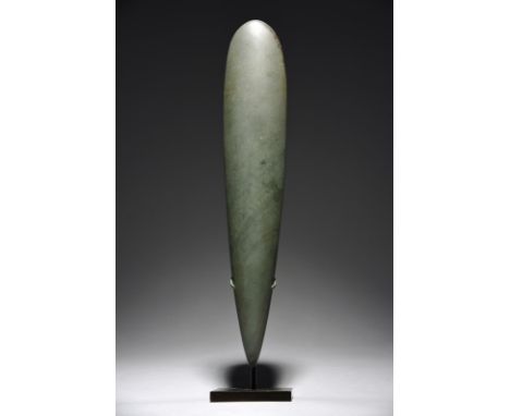 A Lake Sentani obligation stone Irian Jaya, Indonesia greenstone, 43cm long, on a stand. (2) Provenance Victoria, Lady De Rot