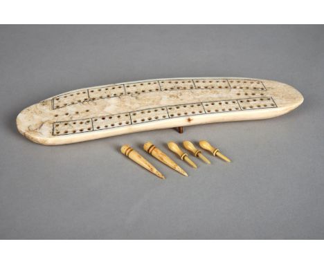 λAn Inuit cribbage board Arctic walrus ivory, with two copper pin supports, the underside inscribed Genuine Walrus Tooth Crib
