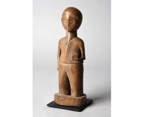 A colon male figure Ivory Coast wearing a beret and holding a small box in his left hand and a cane in his right, 27.5cm high