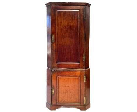 A George III oak standing corner cupboard. The single panelled door opening to reveal four doors, the lower part with a simil