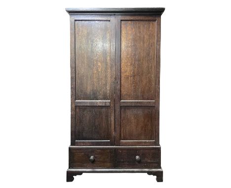 An oak wardrobe, 19th century, With a pair of twin panelled doors, the lower part with two drawers, on bracket feet, height 2