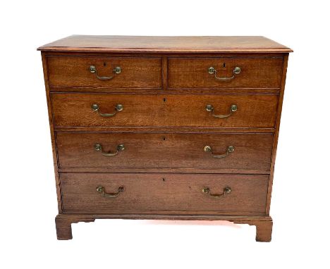 A George III oak chest of drawers. The rectangular moulded top, above two short and three long drawers, on bracket feet, heig