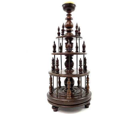 A rosewood bobbin stand, 19th century. The central knopped column surmounted by a domed pin cushion, with three graduated tie