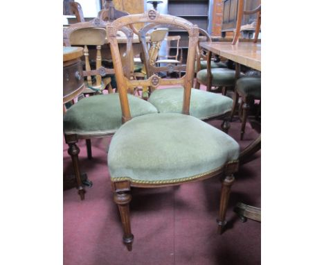 A Set of Eight Walnut Dining Chairs, with shaped top rail and centre panel, upholstered seats, on turned and reeded forefront