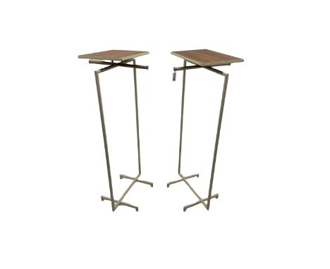 Pair of contemporary shops display clothes rails, rectangular display shelf over burnished metal clothes rails on white finis