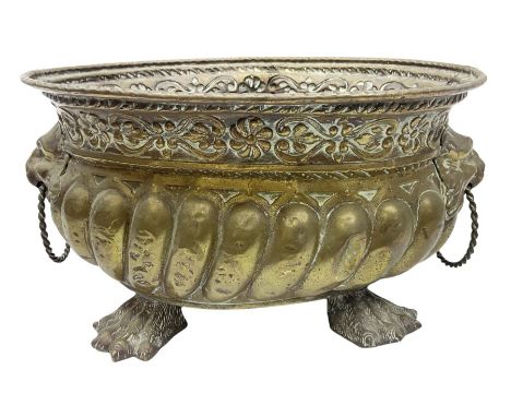 19th century repouss� brass jardiniere with lion mask ring handles, of oval form raised upon four claw feet, L31cm