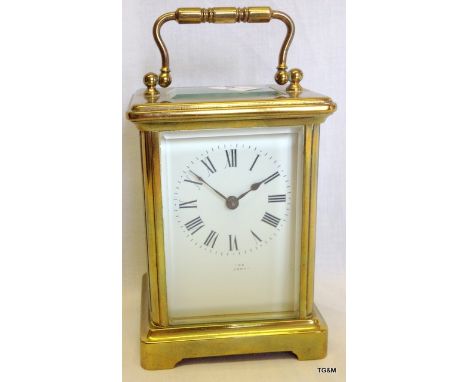 A brass carriage clock with glass panels