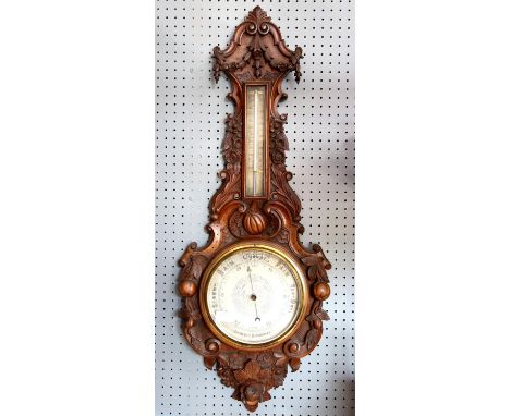 Victorian carved walnut aneroid banjo barometer, with thermometer, the frame carved with fruit, flowers and floral swags, H88