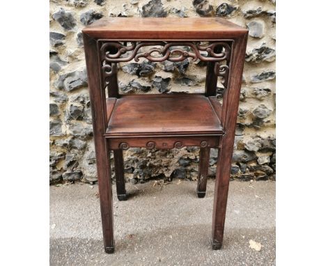 A Chinese hardwood side table, possibly hongmu, the rectangular top above pierced scroll friezes to the front and sides, the 