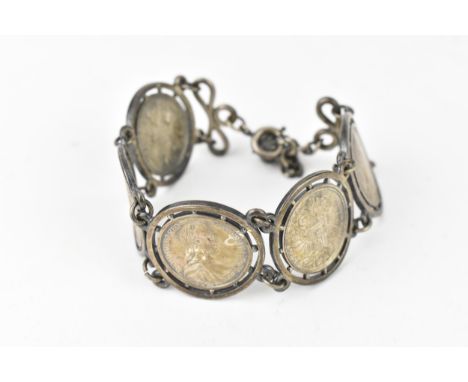 A group of five 1780 Austrian Maria Theresa 1/2 Thaler coins of the Austrian Empire, mounted onto a white metal bracket 