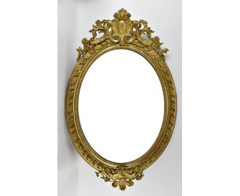 A large 19th century carved and giltwood oval mirror, with pierced acanthus and floral crest, beaded inner border and bevelle