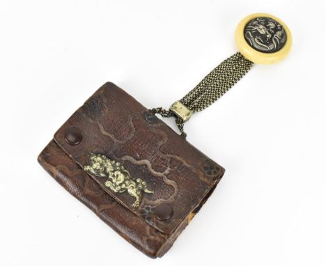A Japanese Meiji period tobacco sagemono (pouch) made from leather, with white metal foo dogs to the front, hanging from a re